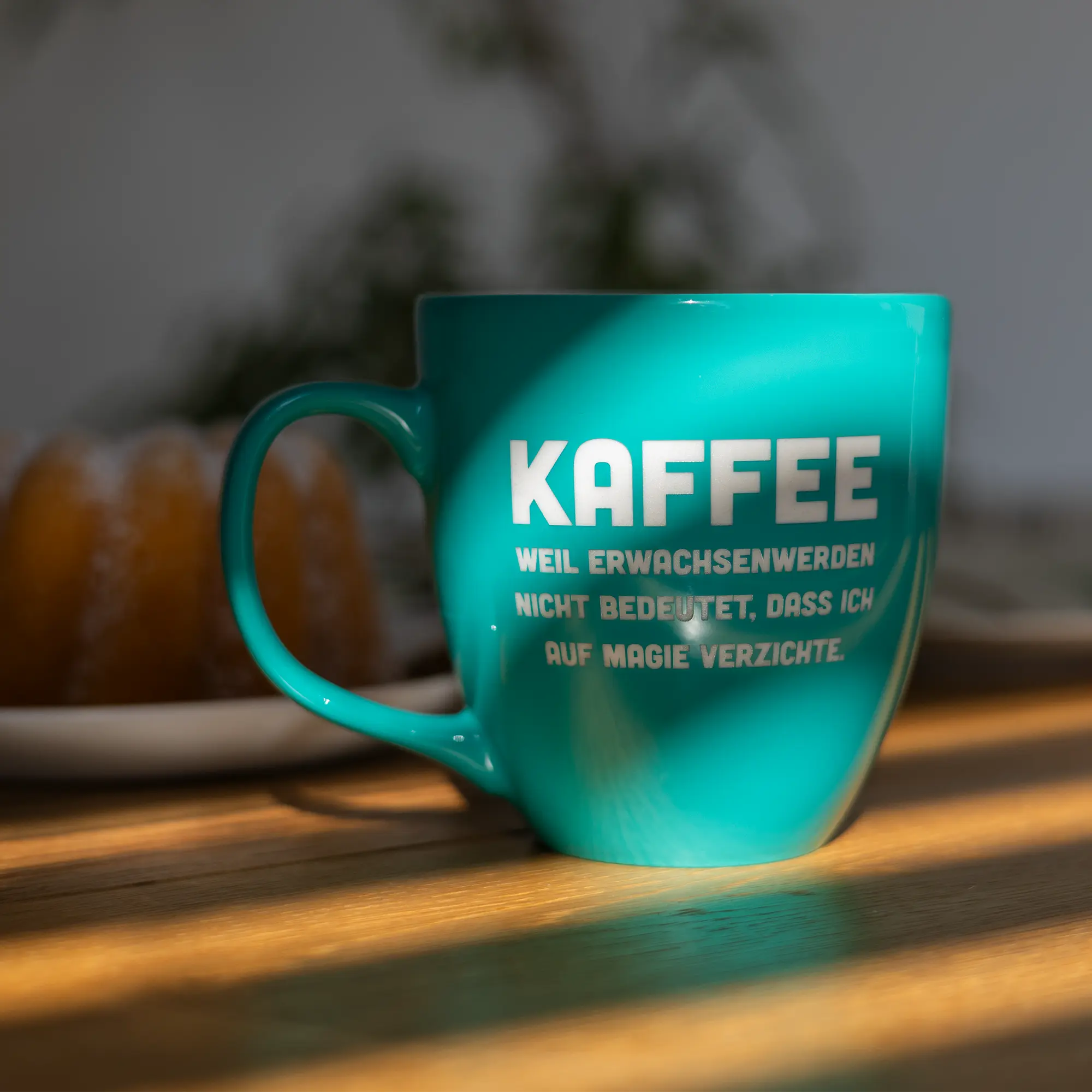 Tasse mit Kaffespruch auf dem Tisch im Schatten