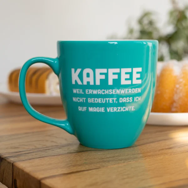 Tasse mit Kaffespruch - Produktbild mit Kuchen im Hintergrund